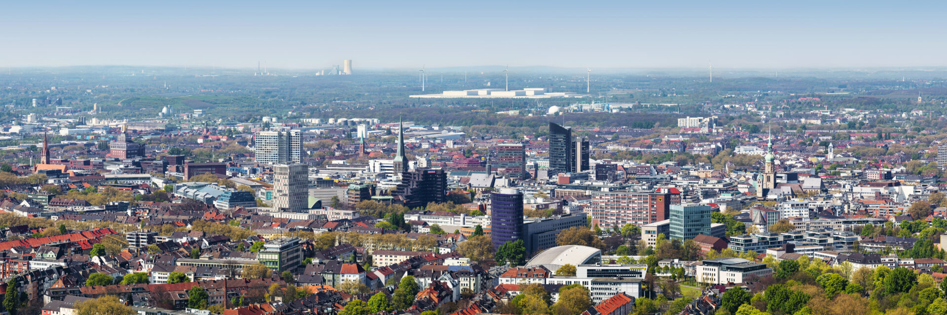 dortmund Weites Stadtpanorama von Dortmund bei klarem Tageslicht mit markanten Hochhäusern, Kirchtürmen, Wohngebäuden und dichtem Baumbestand bis zum fernen Horizont