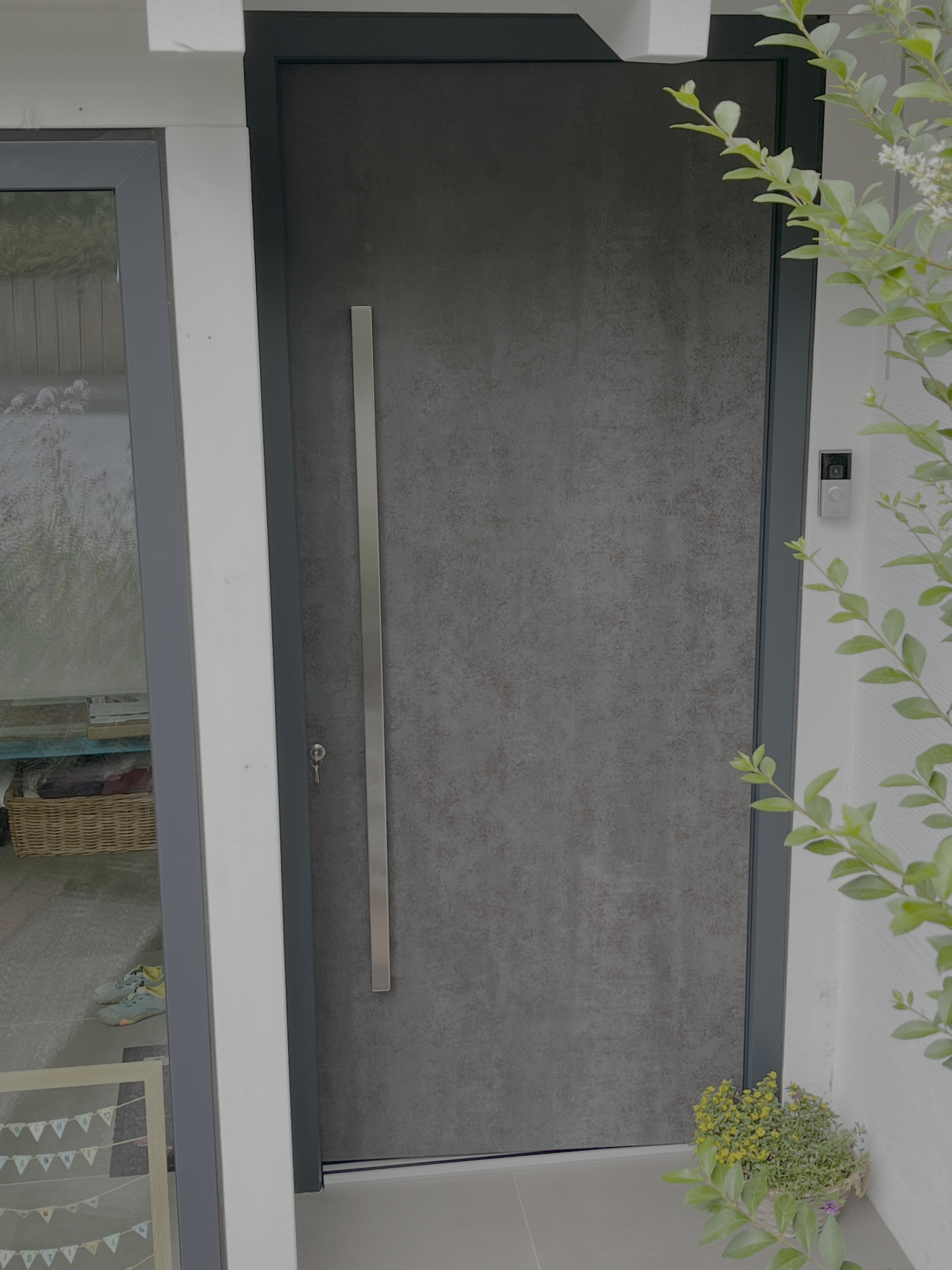 Eingebaute FeBa Aluminiumhaustür in Betonoptik mit anthrazitfarbenem Rahmen und Griffleiste